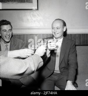 1961, historisch, der Lord Montagu von Beaulieu mit einem Glas Champagner in der Hand, mit anderen, feiert die Geburt seines ersten Sohnes, Ralph Douglas-Scott-Montagu, 4. Baron Montagu von Beaulieu. Der Familiensitz, das Beaulieu Estate in Hampshire, England, mit dem Beaulieu Palace House, einem Gebäude aus dem 13.. Jahrhundert, das ursprünglich Teil der Beaulieu Abbey war, beherbergt das 1952 gegründete National Motor Museum. Montagu, eine Figur von nationaler Bedeutung in Großbritannien, hielt seine Peerage für die drittlängste in der Geschichte Briitschs, insgesamt 86 Jahre und 155 Tage. Stockfoto