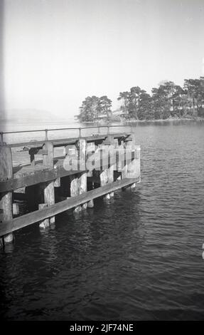 1950s, historisch, Ullswater im Lake District, Cumbria, England und ein Blick aus dieser Zeit auf Howtown Pier, einen Steg, an dem die Ullswater "Steamers" Passagiere für malerische Seereisen sammeln. Stockfoto