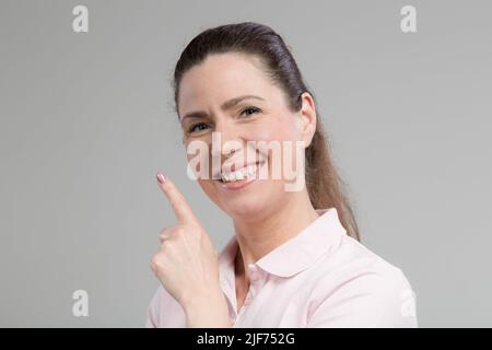 Frau mittleren Alters zeigt, dass sie eine Idee hat Stockfoto