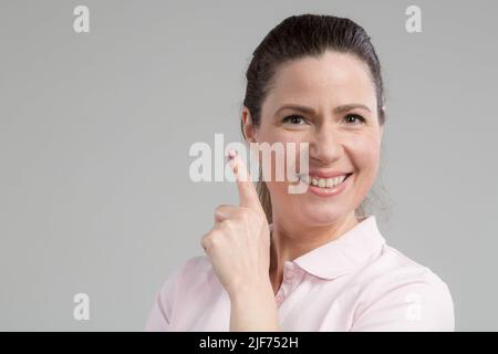 Frau mittleren Alters zeigt, dass sie eine Idee hat Stockfoto