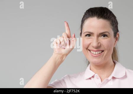 Frau mittleren Alters zeigt, dass sie eine Idee hat Stockfoto