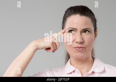 Frau mittleren Alters zeigt emotionale Ausdrücke und denkt Stockfoto