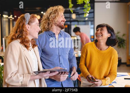Fröhliche kreative Geschäftsmänner und Geschäftsfrauen im Büro Stockfoto