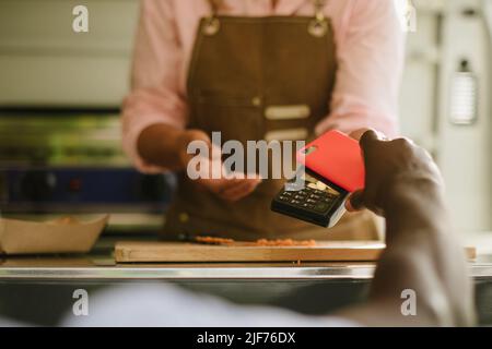 Schwarzer Mann, der für Essen bezahlt Stockfoto