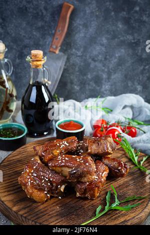 Gegrillte Rippchen in süß-saurer Sauce. Rippchen in Honigsauce mit Kräutern mariniert Stockfoto