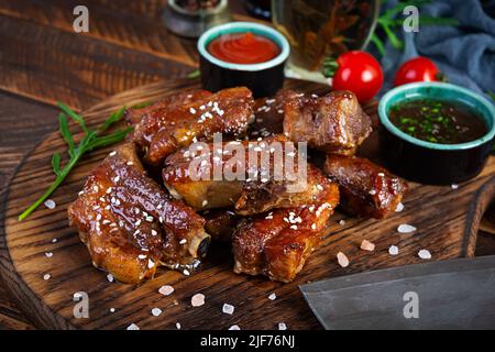 Gegrillte Rippchen in süß-saurer Sauce. Rippchen in Honigsauce mit Kräutern mariniert Stockfoto