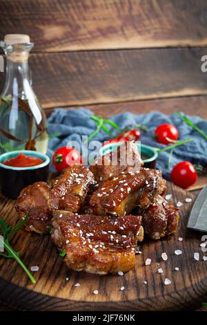 Gegrillte Rippchen in süß-saurer Sauce. Rippchen in Honigsauce mit Kräutern mariniert Stockfoto