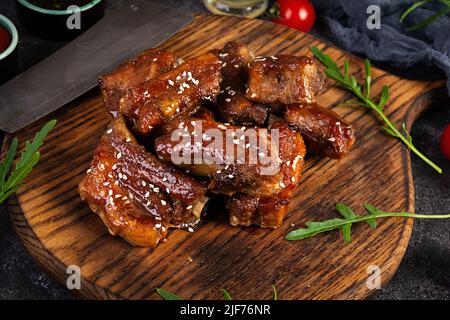 Gegrillte Rippchen in süß-saurer Sauce. Rippchen in Honigsauce mit Kräutern mariniert Stockfoto