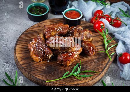 Gegrillte Rippchen in süß-saurer Sauce. Rippchen in Honigsauce mit Kräutern mariniert Stockfoto