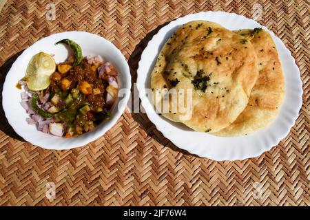 Leckeres nordindisches chhole Kulche-Gericht im punjabi-Delhi-Stil. Chole aus Kichererbsen Chana und Kulcha ist weiches indisches Fladenbrot. Chhole Kulcha Tradition Stockfoto