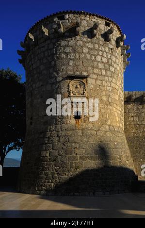 Venezianischer Turm an einer Ecke der mittelalterlichen Burg in Krk, Insel Krk, Kroatien. Die Burg wurde von der kroatischen Frankopanerfamilie oder der französischen Familie erbaut und der Turm stammt wahrscheinlich aus den 1200s Jahren. Als Venedig den Turm 1500 umbaute, wurde jedoch eine Tafel mit dem Emblem von Venedig, dem geflügelten Löwen des Heiligen Markus, in das Steinwerk eingesetzt. Die lateinische Inschrift unter dem Emblem „Aureae Venetorum Libertati“ bedeutet übersetzt „die Goldenen Freiheiten von Venedig“. Stockfoto