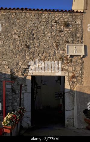 Der frühchristliche Märtyrer St. Quirinus, schutzpatron der Stadt Krk auf der Insel Krk, Kroatien, wird mit einer Steintafel über Mala Vrata, dem kleinen Stadttor in den Verteidigungsmauern, wenige Meter von der mittelalterlichen frühromanischen Kirche St. Quirinus entfernt, gedenkt. Stockfoto