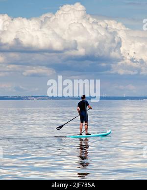 Portobello, Edinburgh, Schottland, Großbritannien. 30.. Juni 2022. Cumulus Wolken oben und eine spiegelartige Oberfläche auf dem ruhigen Firth of Forth für dieses Stand Up Paddlebarder Training am frühen Nachmittag, mit einer Temperatur von 18 Grad Celsius. Kredit: Archwhite/alamy Live Nachrichten. Stockfoto