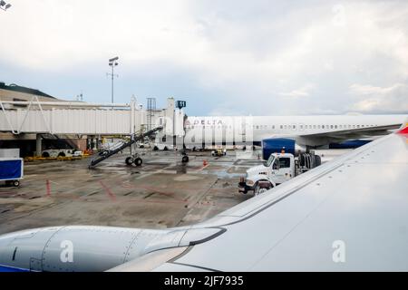 Flugausfälle belasten müde Reisende. Bilder von aktuellen Flugverspätungen in den USA. Gestörte Reisepläne. Flugzeug am jetway. Stockfoto