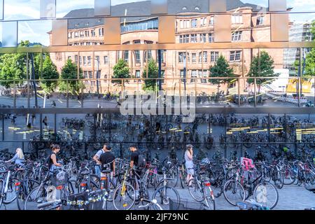 Fahrräder parken vor der spiegelnden Fassade der Universitätsbibliothek Freiburg im Breisgau, Schwarzwald, Baden-Württemberg, Deutschland | Fahrräder Stockfoto