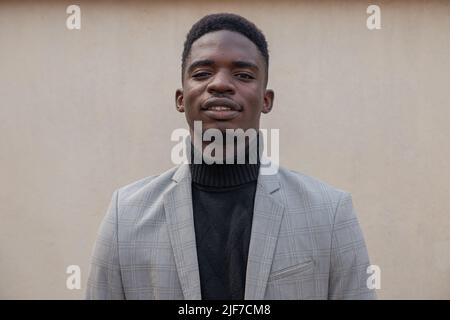 Porträt eines jungen afrikanischen Jungen, elegant gekleidet, isoliert und auf die Kamera blickend Stockfoto