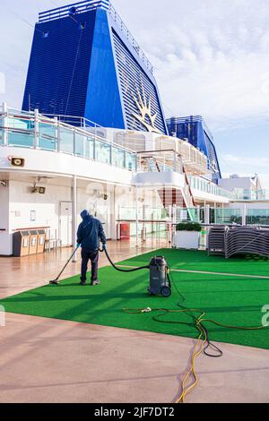 Ein Arbeiter, der die Decks des P&O-Kreuzfahrtschiffs Britannia früh am Morgen reinigt, während er sich Stockholm, Schweden, nähert Stockfoto