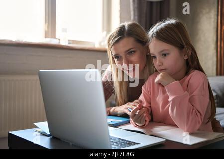 Kind Tochter lernen Online-Kurse mit Mutter zu Hause. Stockfoto