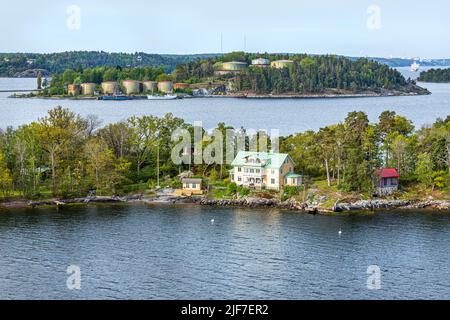 Am Wasser gelegene Grundstücke auf einer der vielen Inseln des Stockholmer Archipels - hier Granholmen, Schweden. Hinter dem Stora Hog befinden sich alte Öllagertanks Stockfoto