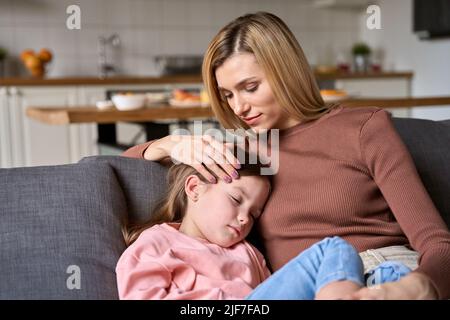 Junge liebevolle Mutter streicheln niedlichen Kind Tochter Bonding sitzen auf Couch. Stockfoto