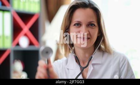 Porträt eines schönen jungen Arztes hält Stethoskop Stockfoto