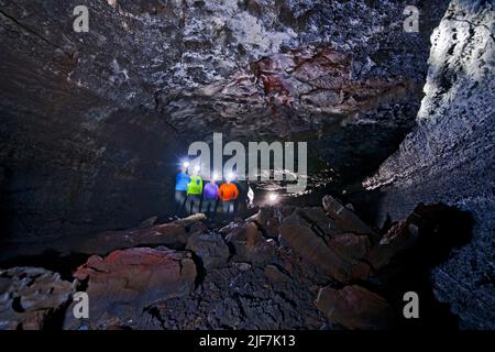 Gruppe von Wissenschaftlern, die die Lavahöhle Leidarendi in Island erkunden Stockfoto