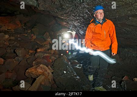 Gruppe von Wissenschaftlern, die die Lavahöhle Leidarendi in Island erkunden Stockfoto