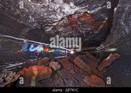 Gruppe von Wissenschaftlern, die die Lavahöhle Leidarendi in Island erkunden Stockfoto