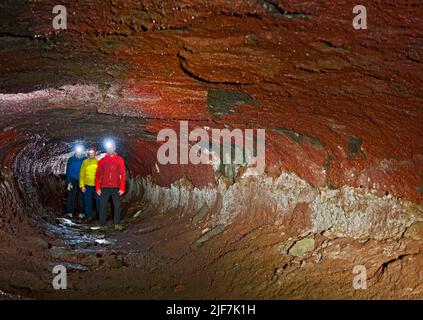 Gruppe von Wissenschaftlern, die die Lavahöhle Leidarendi in Island erkunden Stockfoto