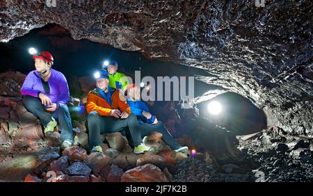 Gruppe von Wissenschaftlern, die die Lavahöhle Leidarendi in Island erkunden Stockfoto