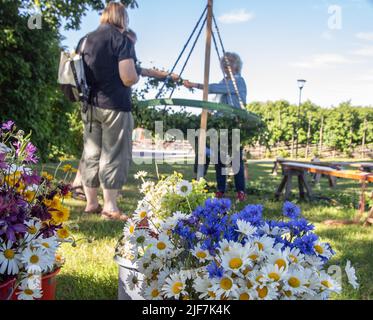 Mittsommer in Schweden binden Eltern und Kinder Blumen auf einem großen Kranz in malmkoping, Schweden Stockfoto