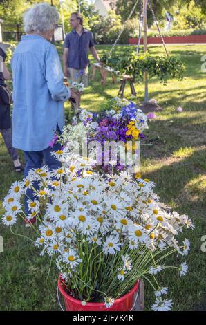 Mittsommer in Schweden binden Eltern und Kinder Blumen auf einem großen Kranz in malmkoping, Schweden Stockfoto