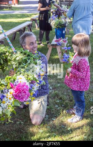 Mittsommer in Schweden binden Eltern und Kinder Blumen auf einem großen Kranz in malmkoping, Schweden Stockfoto