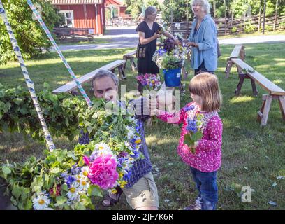 Mittsommer in Schweden binden Eltern und Kinder Blumen auf einem großen Kranz in malmkoping, Schweden Stockfoto