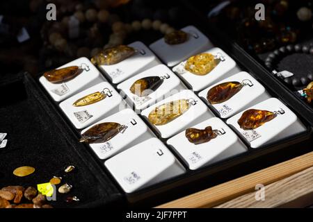 Bernstein Schmuck zum Verkauf, baltische Bernstein Anhänger, Gruppe von Objekten, Detail, extreme Nahaufnahme, Niemand. Glänzendes Naturbernsteinschmuck-Set, poliert Stockfoto