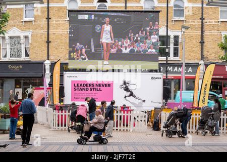 Ein Live-Feed eines Tennisspiels zwischen Katie Boulter und Karolina Pliskova wird von den Londoner Südstaaten im Stadtzentrum von Wimbledon während der zweiwöchigen Meisterschaften der Lawn Tennis Association am 30.. Juni 2022 in London, England, beobachtet. Stockfoto