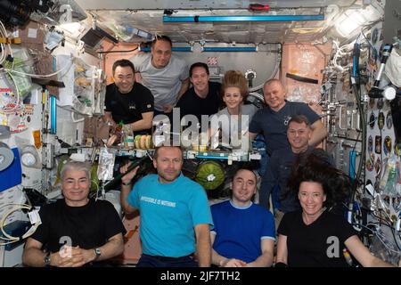 Die zehn Einwohner der Internationalen Raumstation (ISS) werden am 8. Oktober 2021 im Modul Unity zu einer Mahlzeit und einem Porträt versammelt. In der ersten Reihe (von links) befinden sich der NASA-Astronaut Mark Vande Hei, der russische Raumfahrtteilnehmer Klim Shipenko, der Roskosmos-Kosmonaut Pyotr Dubrov und der NASA-Astronaut Megan McArthur. In der hinteren Reihe (von links) sind Astronaut Akihiko Hoshide von der Japan Aerospace Exploration Agency (JAXA); Roskosmos-Kosmonaut Anton Shkaplerov; Astronaut Thomas Pesquet von der ESA (European Space Agency); russische Raumfahrtteilnehmerin Yulia Peresild; Roskosmos Kosmonauten Stockfoto