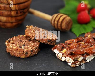 Mandelriegel und Müsli-Kekse, verfeinert mit Honig und Obst, einem Protein-Snack für eine ballaststoffreiche Ernährung Stockfoto