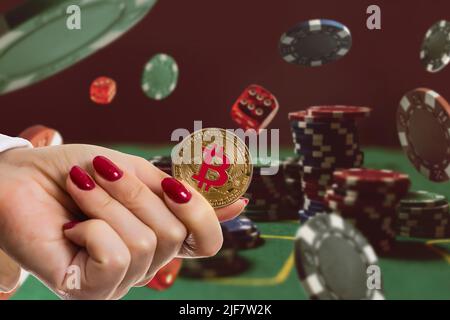 Bitcoin Goldmünze mit Pokerchips auf einem grünen Pokertisch vor schwarzem Hintergrund. Blockchain-Casino. Online-Glücksspiel Stockfoto