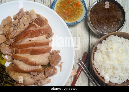 Geschmortes Schweinekeule mit eingelegtem Senf. Gekochte Schweinshaxe mit chinesischen Kräutern. Serviert mit Thai-Stil eingelegten Chilis in Essig Stockfoto