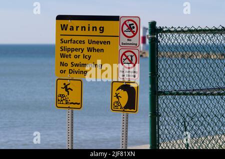 Warnschild am Pier am Eingang zum Hafen von Lake Michigan, Two Riverers, Wisconsin. Stockfoto