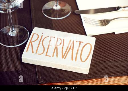 Reserviertes Schild in italienischer Sprache auf einem Tisch im Restaurant Stockfoto