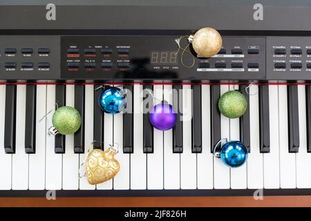 Neujahrskomposition auf einem musikalischen Synthesizer. Lichter einer Girlande. Frohe Weihnachten Grußkarte. Frohes Neues Jahr Stockfoto