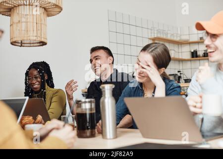 Fröhliche Kollegen diskutieren während des Meetings im Büro Stockfoto