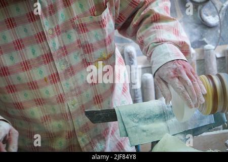 Handwerkliches Polieren, Finishing, eine kleine Alabasterschale auf einem Rad, in einer Werkstatt in Volterra, Toskana, Italien. Stockfoto