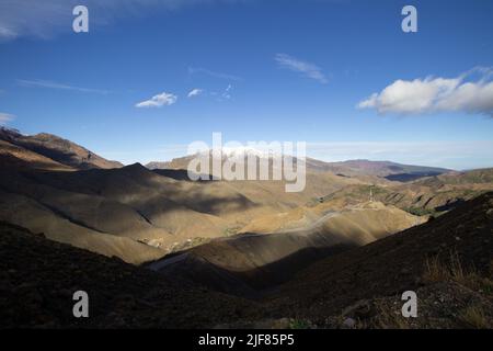 Schatten auf der Hügelseite mit einem klaren blauen Himmel im Hohen Atlas Stockfoto