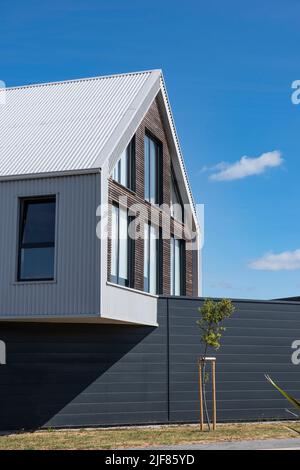 Modernes Haus mit einem Zaun und einem Baum Stockfoto