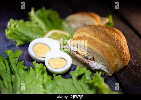 Frisches Thunfisch-Croissant, Salatblatt und Ei. Stockfoto