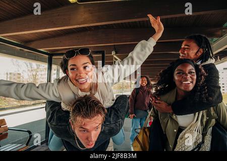 Mann und Frau Huckepack glückliche Freunde am Bahnhofssteig Stockfoto