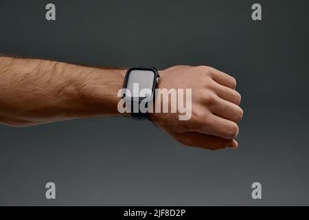 Nahaufnahme mit männlicher Hand. Mann mit schwarzer Smart-Uhr, der nach dem Training die Herzfrequenz überprüft, Speicherplatz kopieren Stockfoto